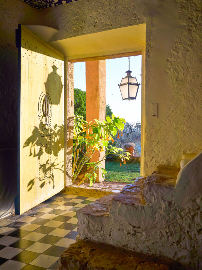 Blick durch die offene Holztür aus dem salle arabe im Castello San Peyre auf den Garten.